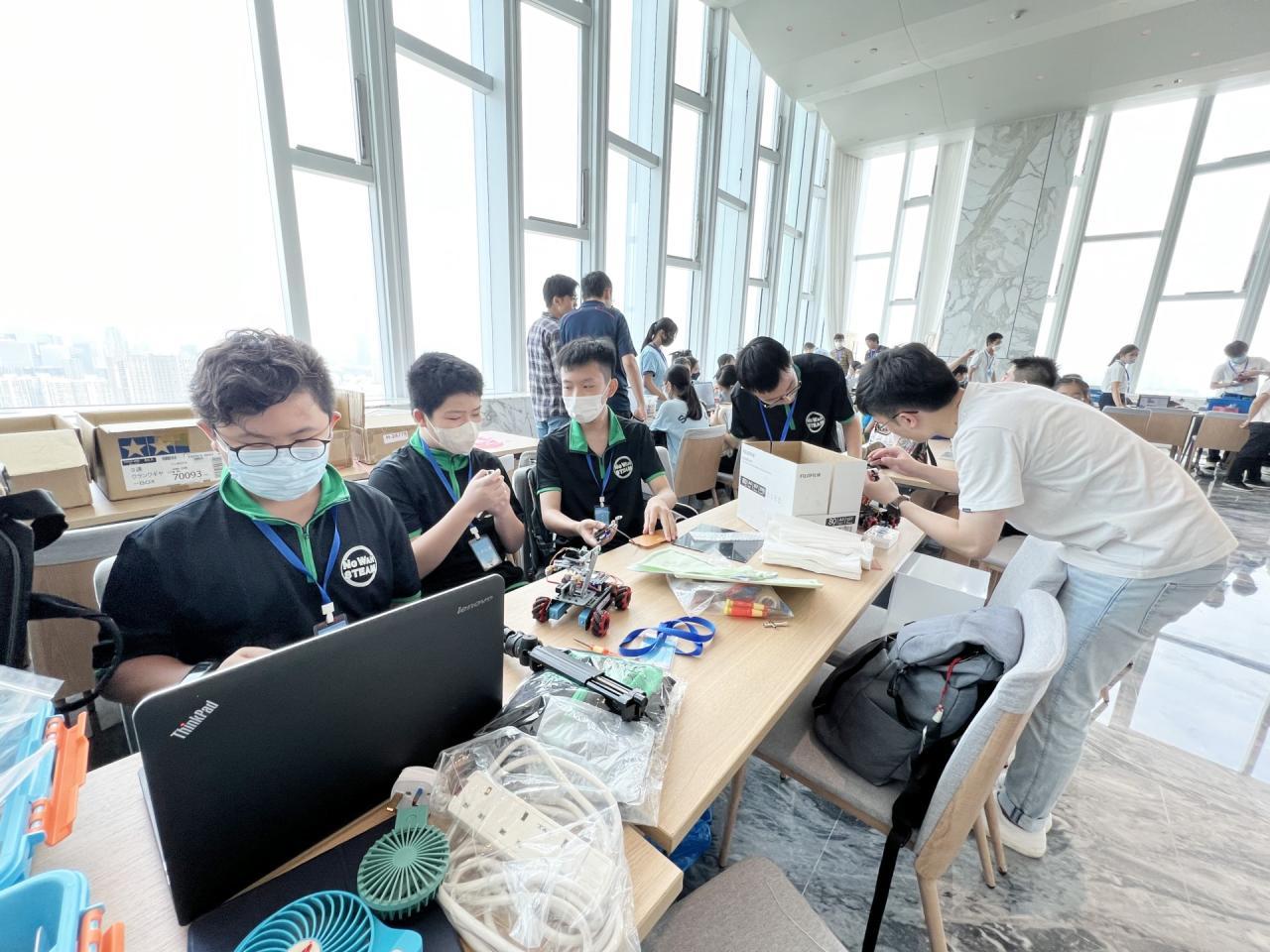  學生在完成第一場比賽後，對AI車和IoT車進行了調整，同時確保硬件正常運作，為接下來的比賽做好準備。 